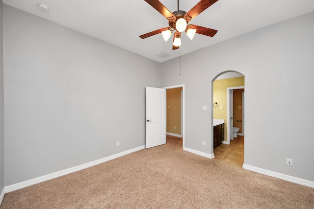 unfurnished bedroom featuring connected bathroom, ceiling fan, and light carpet