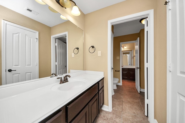 bathroom featuring tile patterned flooring, vanity, and toilet