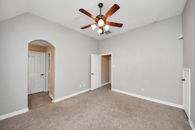 carpeted empty room featuring ceiling fan and vaulted ceiling