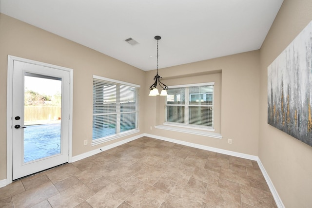 unfurnished dining area with a chandelier and plenty of natural light