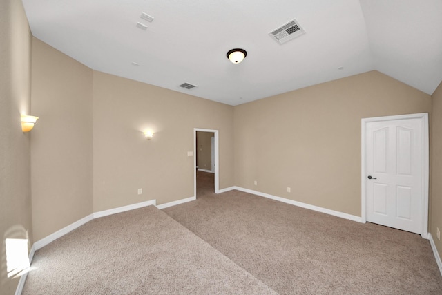 carpeted spare room with lofted ceiling