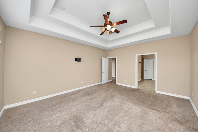 unfurnished bedroom with a raised ceiling, ceiling fan, and light colored carpet