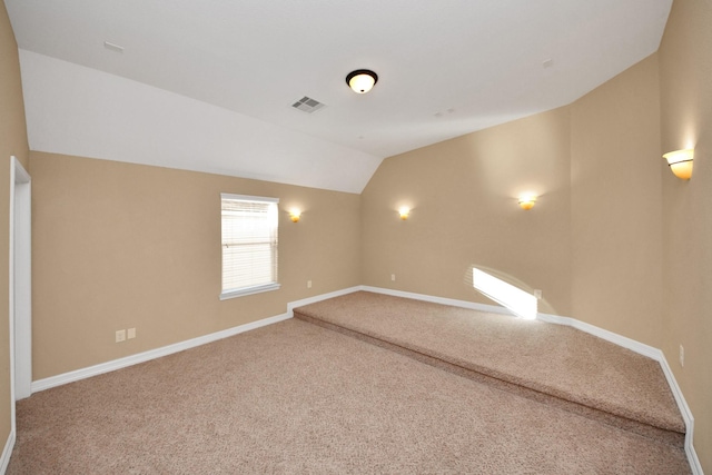 spare room featuring carpet flooring and lofted ceiling