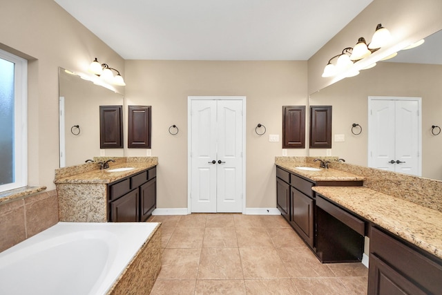 bathroom featuring tile patterned floors, vanity, and a relaxing tiled tub