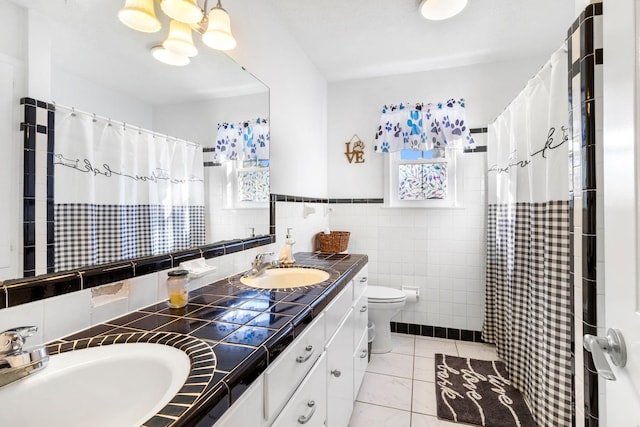 bathroom with vanity, toilet, tile walls, and curtained shower