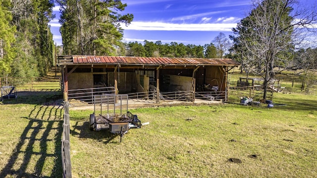 back of house with a rural view and an outdoor structure