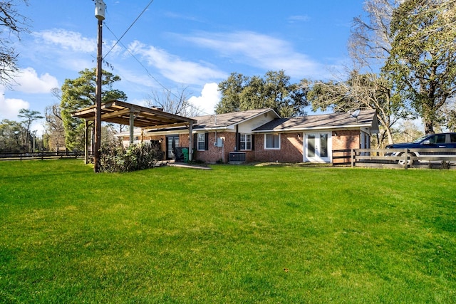 back of house with central AC unit, a pergola, a yard, and french doors