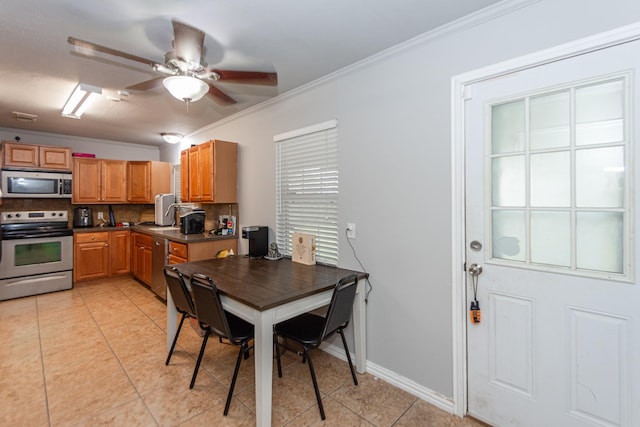 kitchen featuring ceiling fan, ornamental molding, light tile patterned floors, decorative backsplash, and appliances with stainless steel finishes