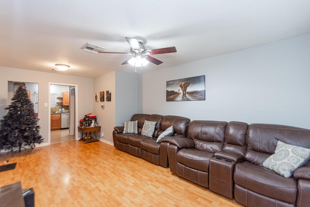 living room featuring ceiling fan and light hardwood / wood-style floors