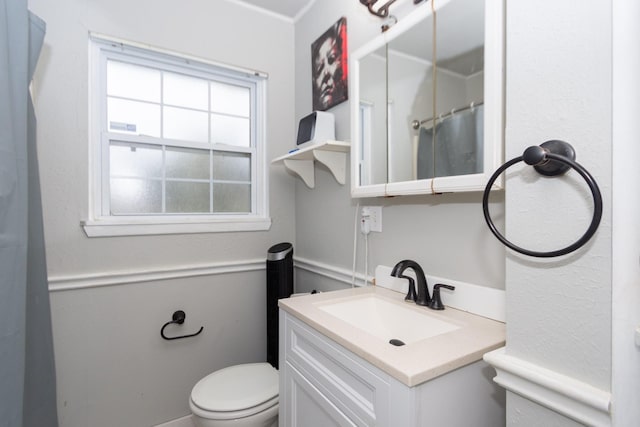 bathroom featuring toilet, vanity, and a shower with curtain