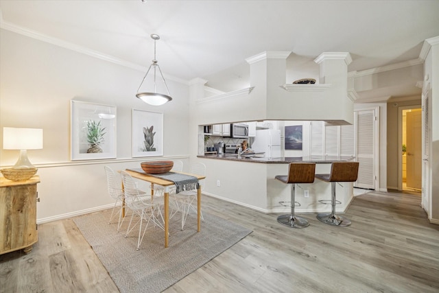 dining area featuring light hardwood / wood-style flooring, ornamental molding, and sink