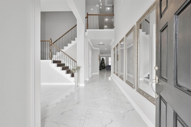 foyer entrance with a towering ceiling and crown molding