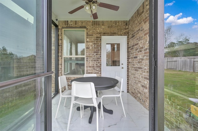 sunroom featuring ceiling fan and a wealth of natural light