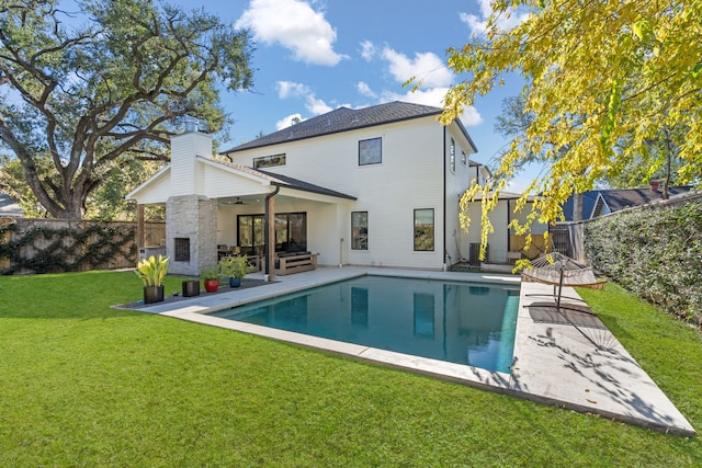 back of property featuring a patio, a yard, outdoor lounge area, a fenced in pool, and ceiling fan