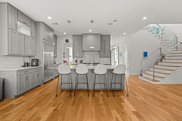 kitchen with hanging light fixtures, light hardwood / wood-style floors, and gray cabinetry