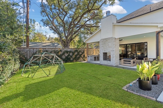 view of yard with a patio area and an outdoor stone fireplace