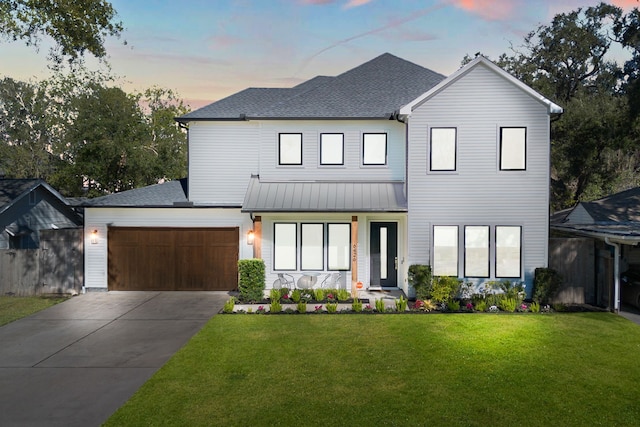 view of front of house featuring a garage and a lawn