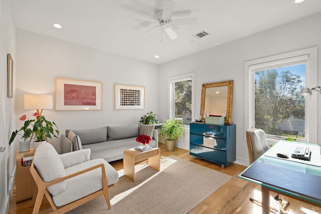 living room featuring ceiling fan, light hardwood / wood-style floors, and a healthy amount of sunlight