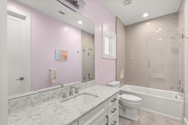 full bathroom with tile patterned flooring, tiled shower / bath combo, vanity, and toilet