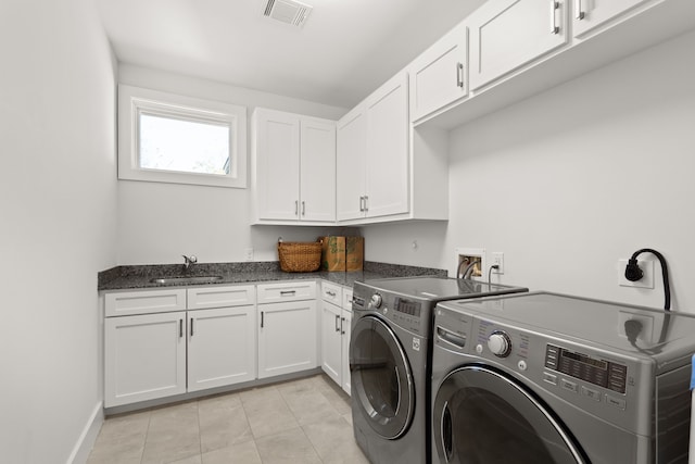 washroom featuring washer and dryer, light tile patterned flooring, sink, and cabinets