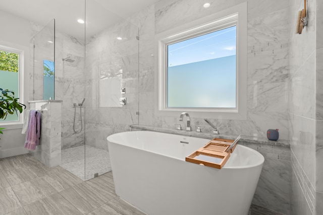 bathroom featuring tile walls and independent shower and bath