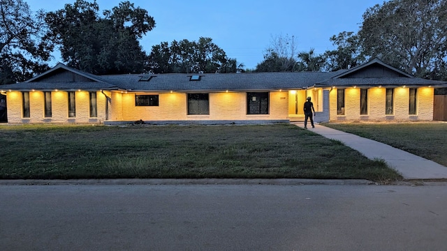 view of front of home with brick siding and a front yard