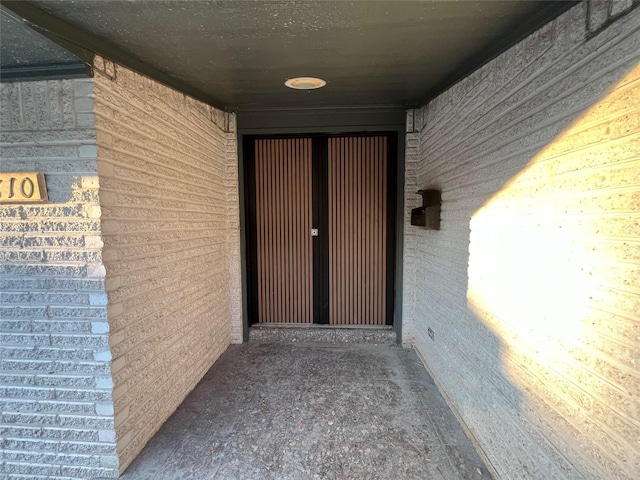 doorway to property with brick siding