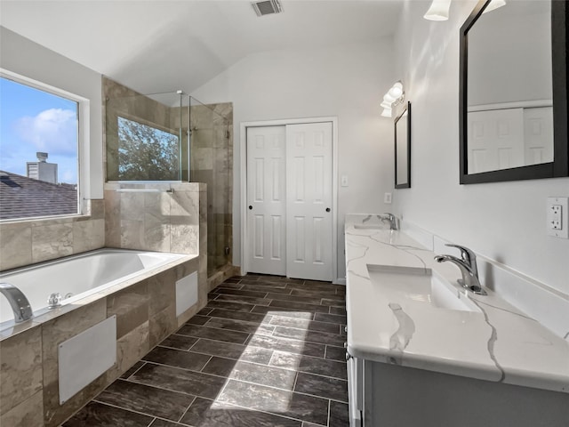 bathroom featuring lofted ceiling, plus walk in shower, and vanity