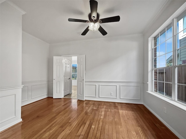 spare room featuring ceiling fan, hardwood / wood-style floors, and crown molding