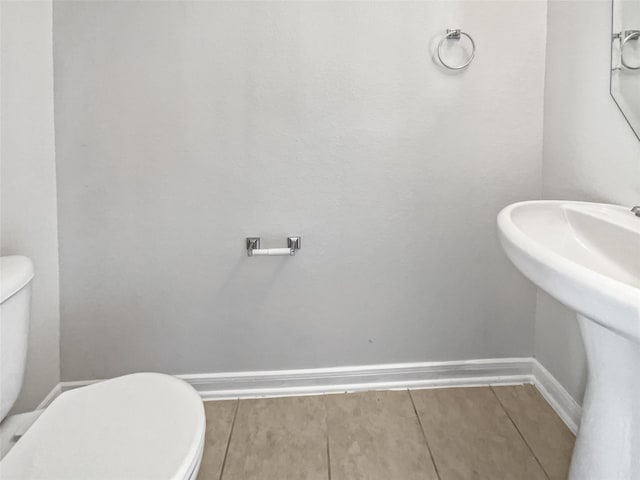 bathroom featuring toilet, tile patterned floors, and sink