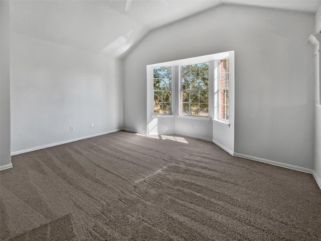 interior space featuring lofted ceiling and dark carpet