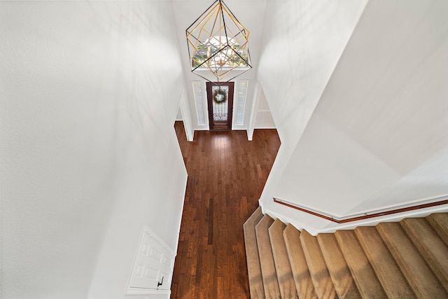 foyer featuring dark wood-type flooring and a chandelier