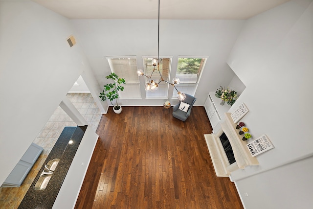 unfurnished living room with a chandelier and dark hardwood / wood-style floors