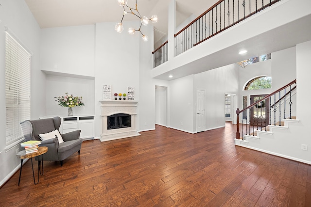 sitting room featuring a notable chandelier, dark hardwood / wood-style floors, and a high ceiling