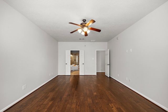 unfurnished bedroom with ceiling fan, dark hardwood / wood-style flooring, and a textured ceiling