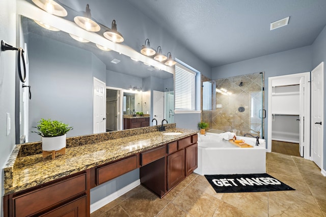 bathroom with vanity, a textured ceiling, and independent shower and bath