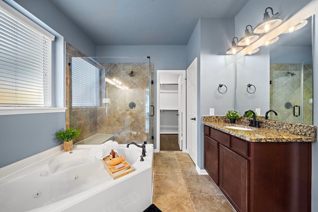 bathroom featuring plus walk in shower, a textured ceiling, vanity, and tile patterned floors