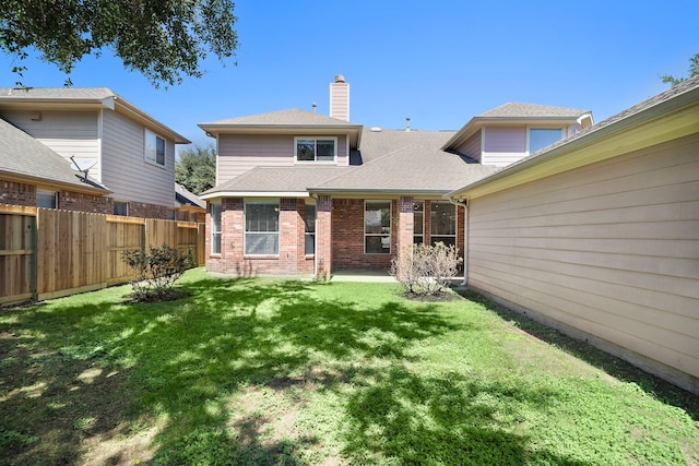 rear view of property with a yard