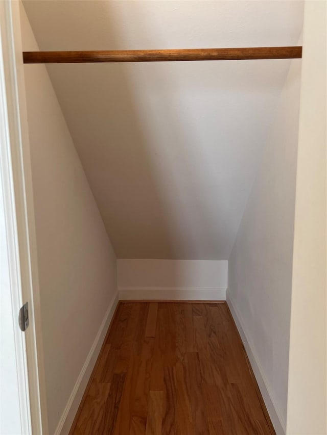 spacious closet featuring hardwood / wood-style floors and lofted ceiling