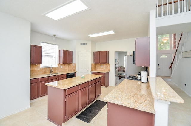 kitchen with kitchen peninsula, sink, a center island, and black dishwasher