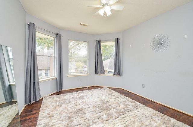 unfurnished room with ceiling fan and dark wood-type flooring