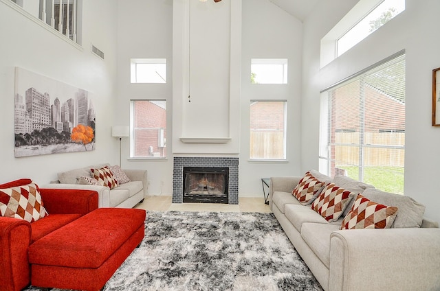 living room featuring a tile fireplace and a towering ceiling