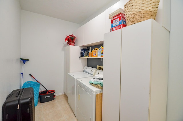 clothes washing area featuring cabinets and washing machine and dryer