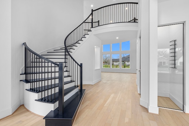 staircase featuring a high ceiling and wood-type flooring