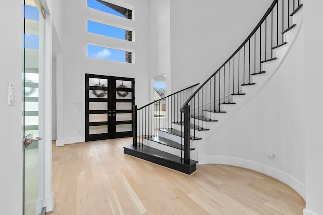 foyer entrance featuring french doors, hardwood / wood-style floors, and plenty of natural light