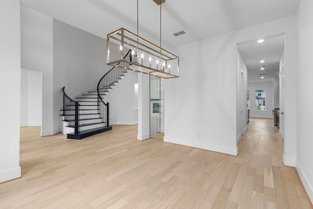 unfurnished dining area featuring light hardwood / wood-style floors and an inviting chandelier