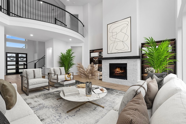 living room with a fireplace, hardwood / wood-style floors, and a high ceiling