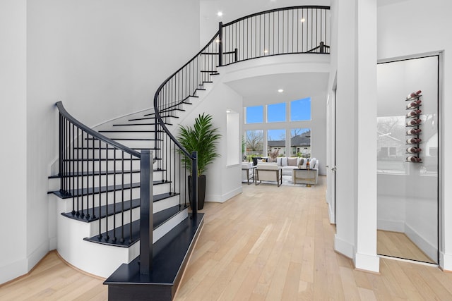 staircase featuring hardwood / wood-style floors and a high ceiling