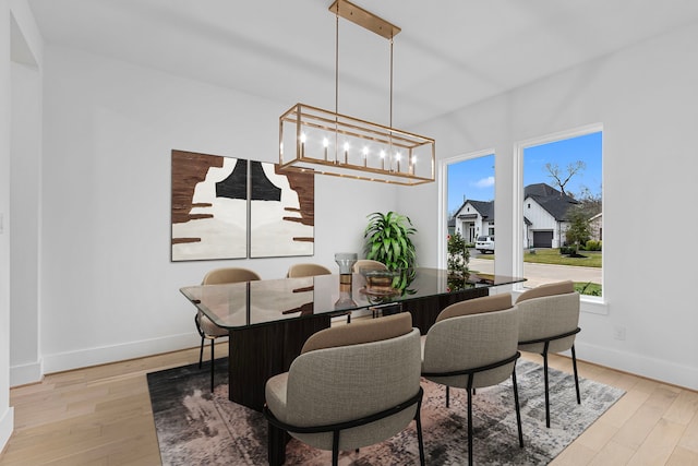 dining space featuring light hardwood / wood-style flooring and a chandelier