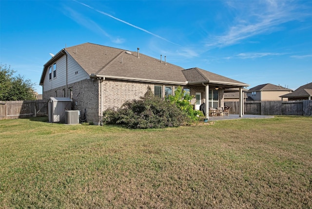 back of property with a lawn, a patio area, and central AC unit